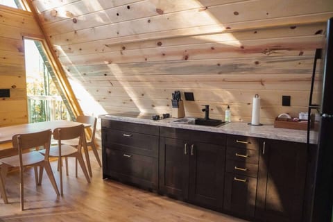 Sunlit cabin kitchenette with dining nook and warm wood interiors