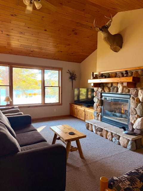 Cozy lakeside living room with stone fireplace and stunning views