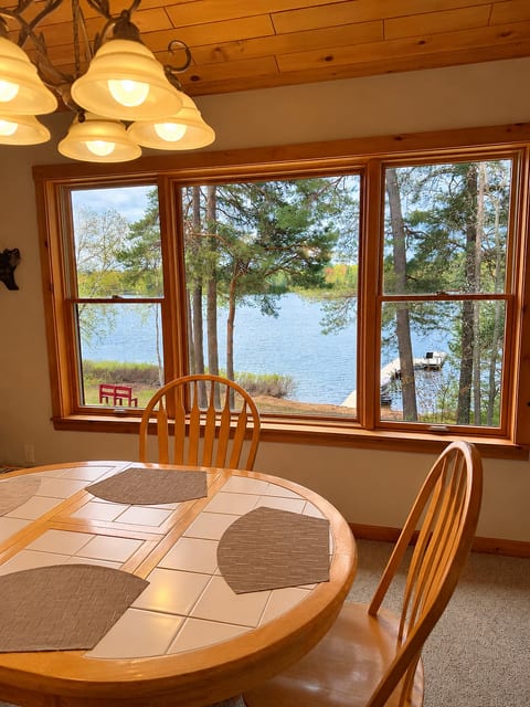 Cozy lakeview dining nook with large windows and serene waterfront views