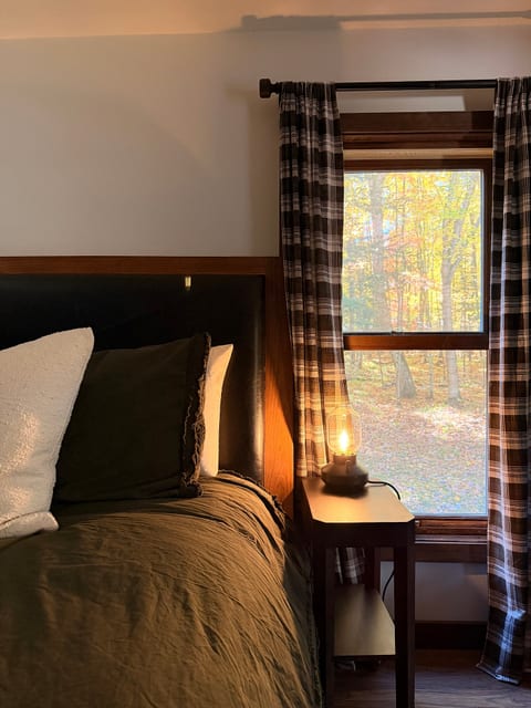 Cozy bedroom with warm lighting and serene woodland views