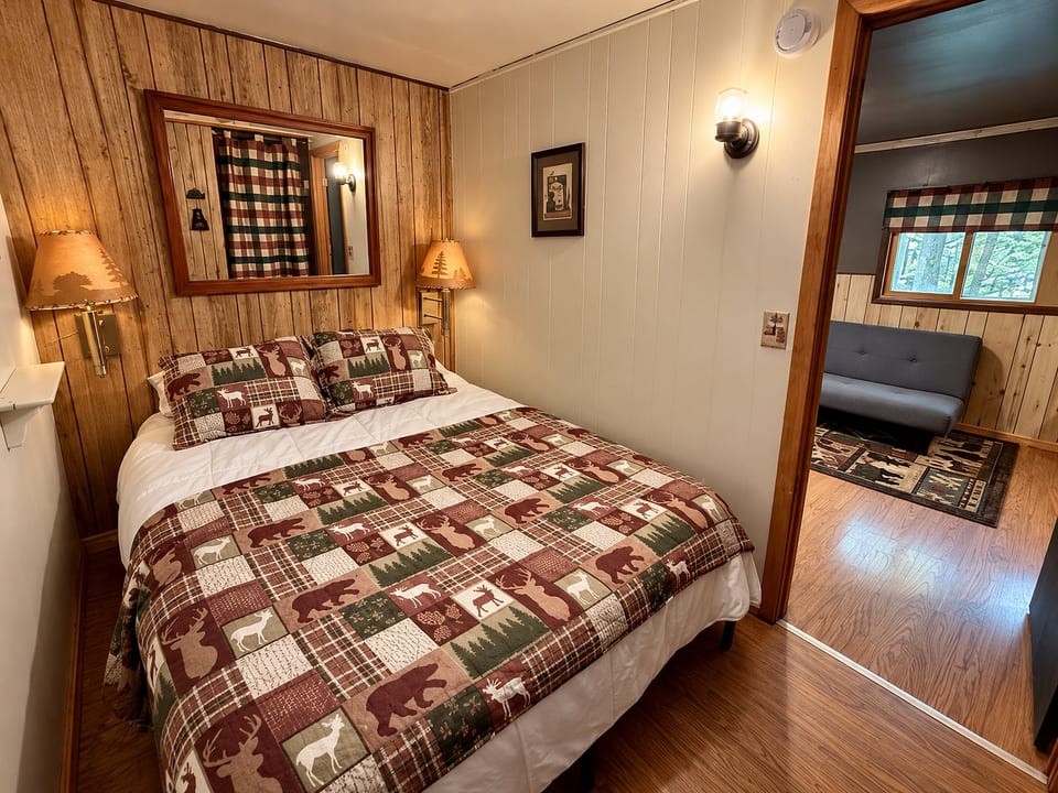 Cozy cabin-style bedroom with rustic charm and adjoining sitting area