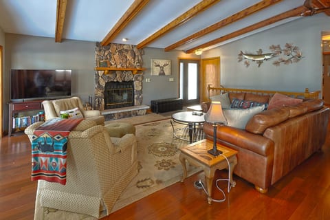 Cozy lodge-style living room with stone fireplace and warm wood accents