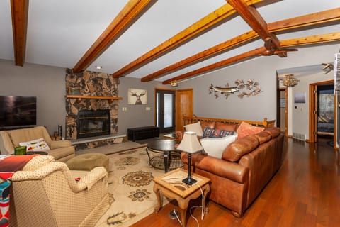 Cozy rustic living room with stone fireplace and exposed wood beams