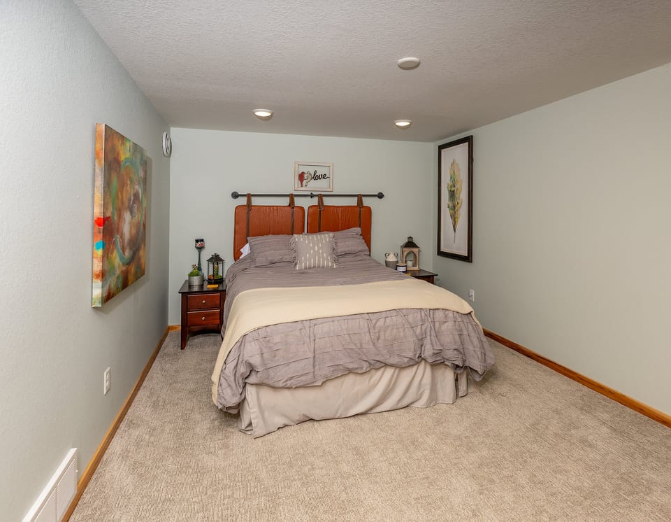 Spacious, cozy bedroom with plush carpeting and warm, relaxing decor