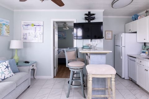 The main room brings everything together in one open, comfortable space. From the sofa to the dining island and kitchen, it’s easy to move through the condo, unpack, and settle in without feeling crowded.