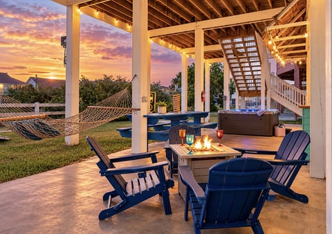 Sunset outdoor retreat with hot tub, hammock, and cozy fire pit seating