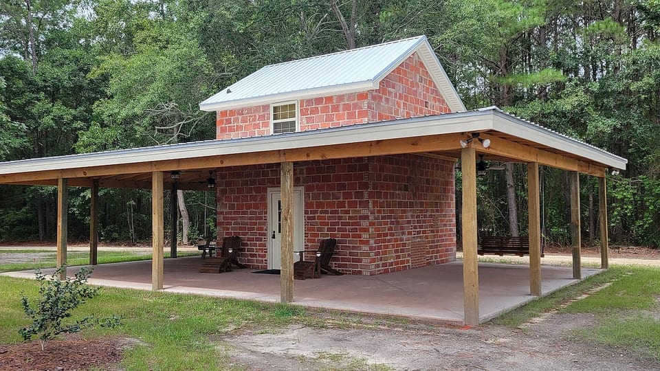 Baccer Barn has a huge covered porch complete with lighted ceiling fans, to keep the breeze flowing, and adirondack chairs and a large swing to relax in.