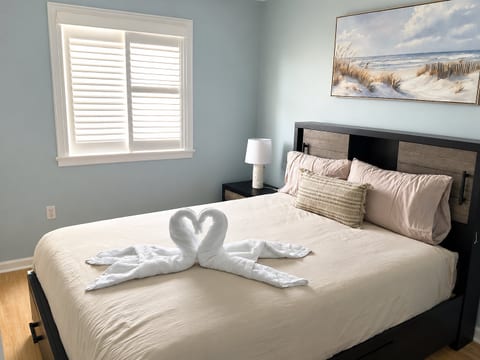 Bright coastal bedroom with plush king bed and charming welcome touches