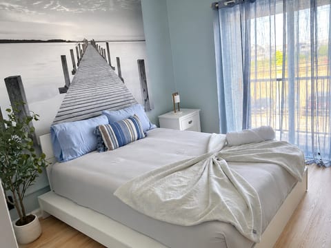 Bright coastal bedroom with waterfront mural and soft natural light