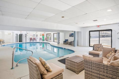 Bright indoor pool with comfy lounge seating for year-round relaxation