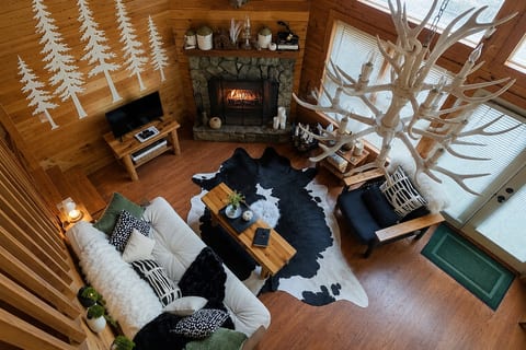Cozy living room with luxury gas fireplace, antler chandelier, and rustic alpine décor. Perfect for curling up with a book or sharing stories after a day in Helen!
