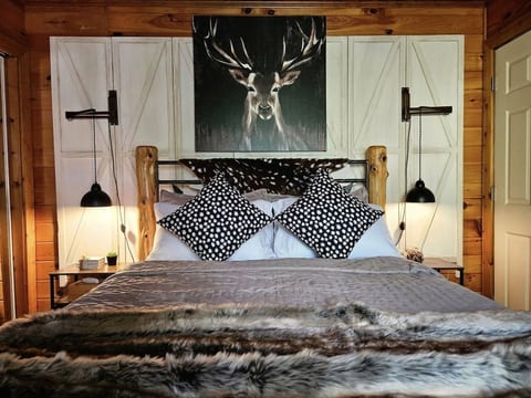 Fawn’s Hideaway — a cozy bedroom with rustic log bed, faux-fur accents, and alpine décor. Designed for comfort and romance, this serene space invites you to relax after exploring Helen and the North Georgia mountains.