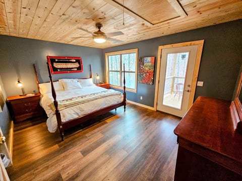 Master bedroom featuring native wood accents, king bed, and private view of the surrounding woods.