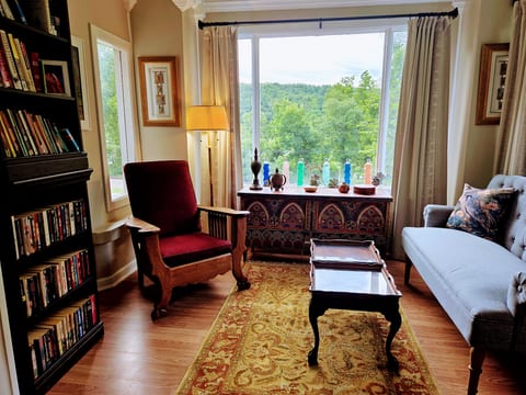 Cozy reading nook with big picture window and serene treetop views