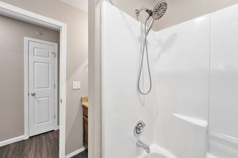 Hall bath with a tub and shower, right by the bunk room and the second bedroom.