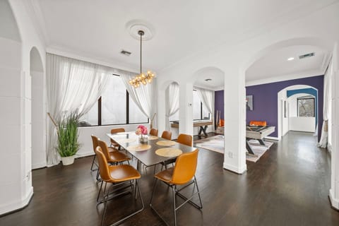 Elegant & Open Dining Area–stunning 94” table w/seats for 8, illuminated by modern bubble globe chandelier. Open to kitchen, living room, & game room, this space fills w/natural light from expansive windows, perfect setting for meals & conversation.