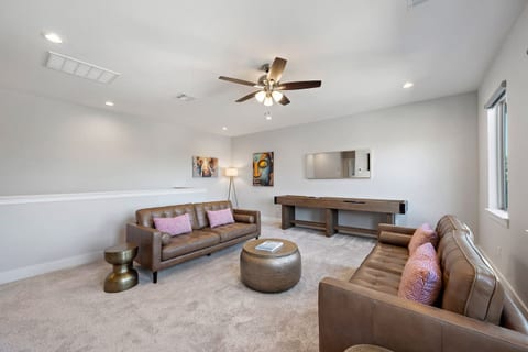 Enjoy the spacious 3rd floor game room with comfortable leather couches, Shuffleboard table, and flat screen TV.