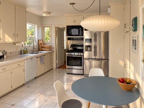 Kitchen with breakfast table and stainless steel appliances.