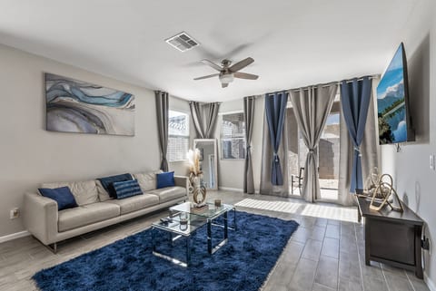 Bright modern living room with stylish decor, TV, and patio access