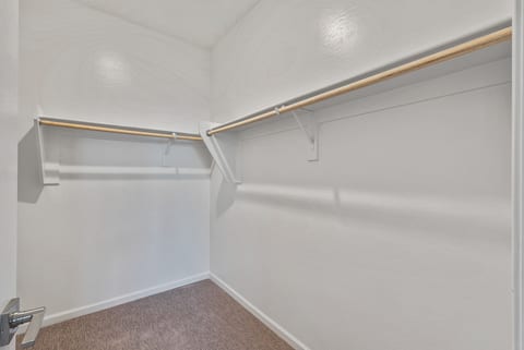 Spacious walk-in closet with ample hanging space and a clean, bright design