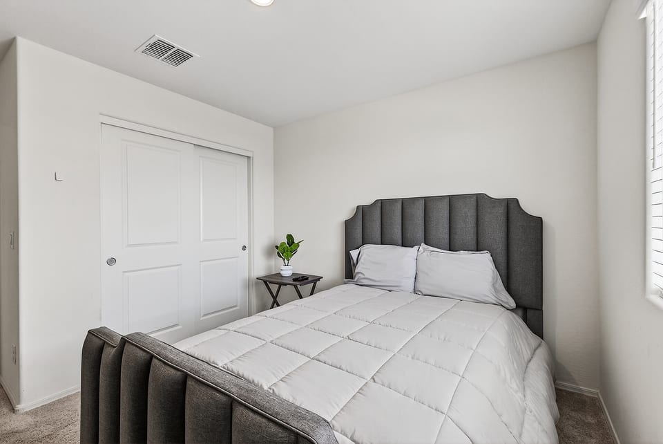 Bright, cozy bedroom with plush upholstered bed and natural light