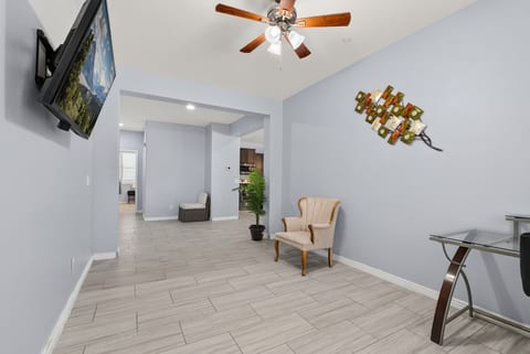 Bright open living space with wall-mounted TV, desk, and stylish decor