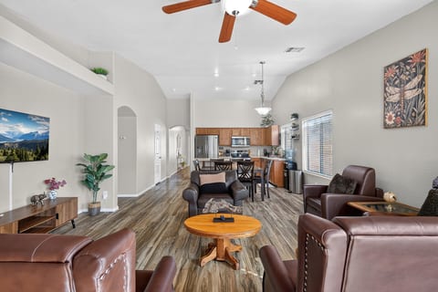 Bright open-concept living room and kitchen with comfy seating and vaulted ceilings