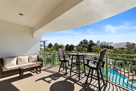 Covered balcony with pool views and inviting outdoor lounge seating