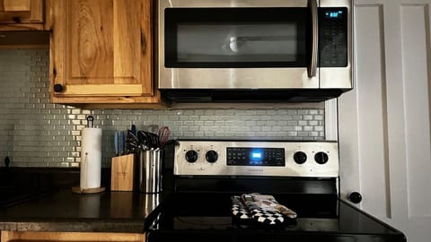 Full Kitchen | Equipped with full size stove and oven, microwave, toaster, cutlery, pots and pans, dining table with 3 stools. Cook your favorite meals or heat up your leftovers from the many tasty restaurants in walking distance.