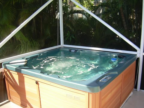 Deluxe Hot Tub with Waterfall & Colored LED Lights Overlooks Tiki Garden
