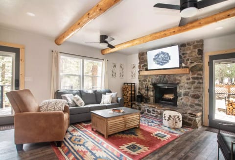 Comfy living room with sofa, recliner, 2 accent chairs, and rock fireplace