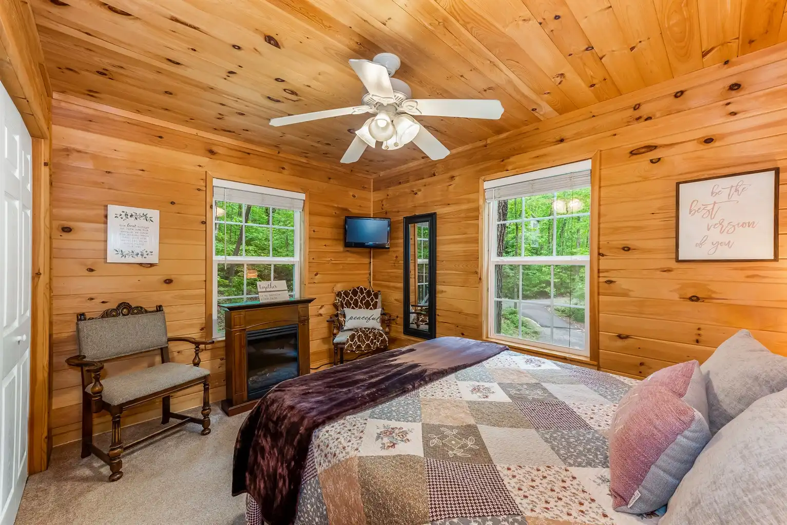 Primary bedroom with Queen 12" memory foam mattress, elec. fireplace and Roku tv - Peaceful Hideaway Treehouse - Fort Payne