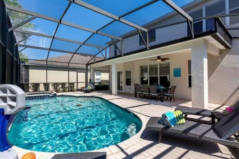 The covered lanai, lounge chairs & basketball hoop, salt water pool & spa