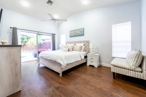 Primary Bedroom with King bed, SmartTV, ensuite bathroom, walk-in closets, and access to the pool and hot tub.