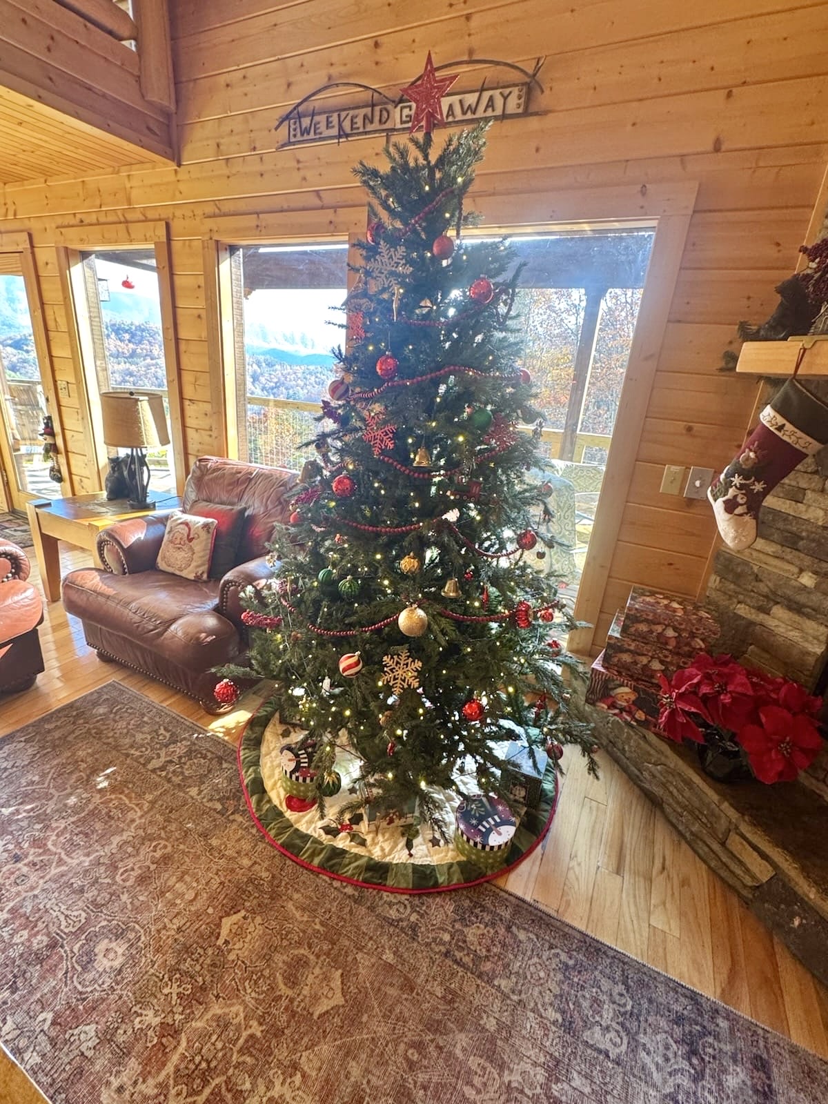 Cozy up by the crackling fireplace beside a beautifully decorated Christmas tree, where twinkling lights and stockings bring the cabin’s holiday spirit to life.