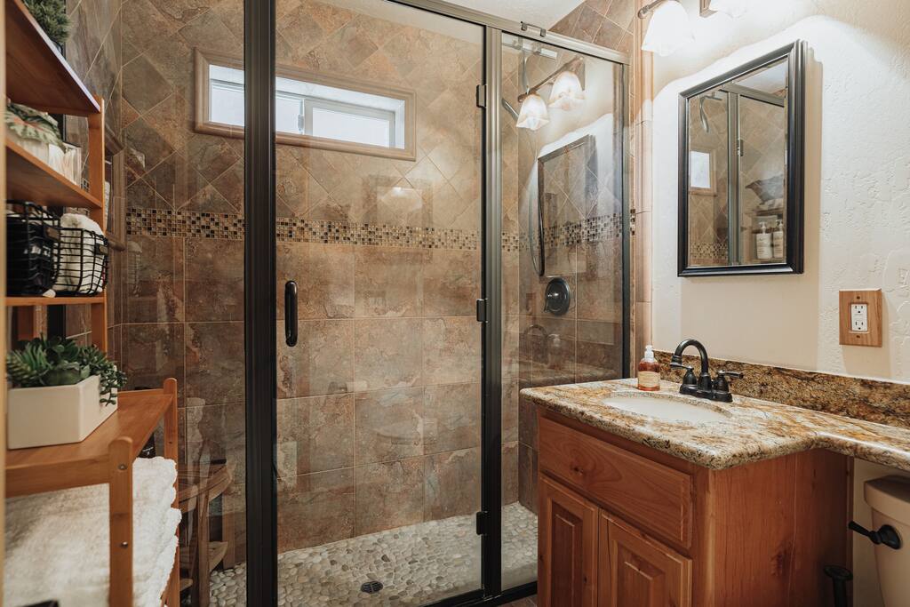 A spa like bathroom experience awaits you! Walk into an oversized shower with a natural smooth river rock flooring and an adjustable handheld showerhead. The cabin’s bathroom is equipped with an overhead ceiling heater so no one gets cold.