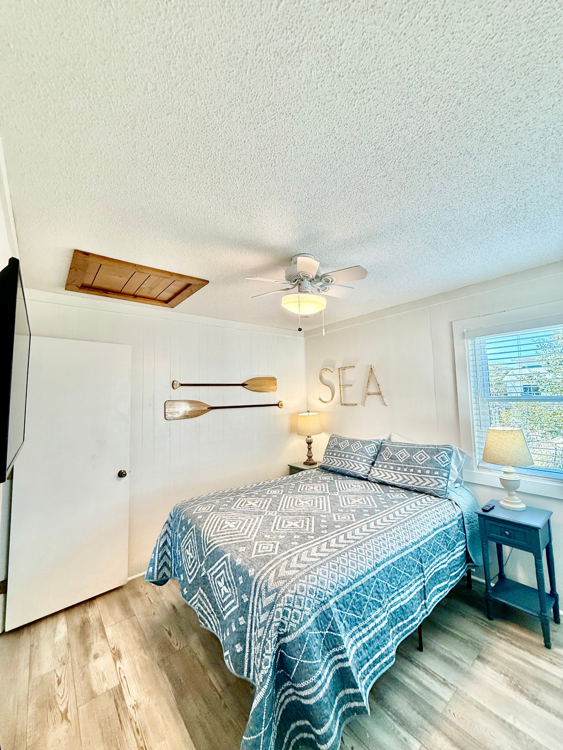 Queen Bedroom on 18" bedframe. Bedside tables with lamps, wall mounted TV, closet.