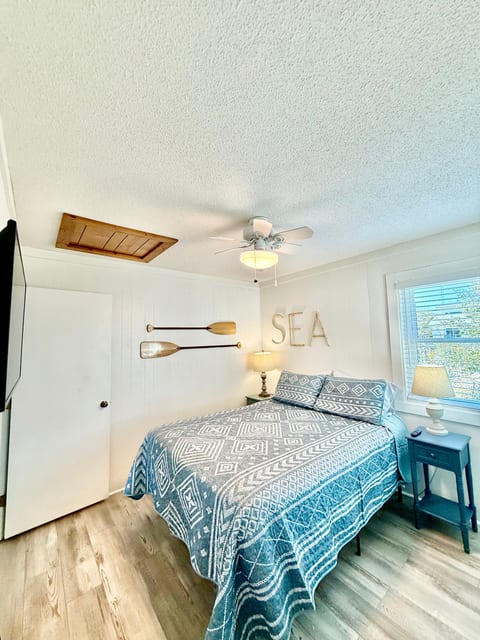 Queen Bedroom on 18" bedframe. Bedside tables with lamps, wall mounted TV, closet.