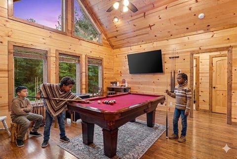 Experience the ultimate relaxation with a game of pool and a stunning view of vaulted ceilings.