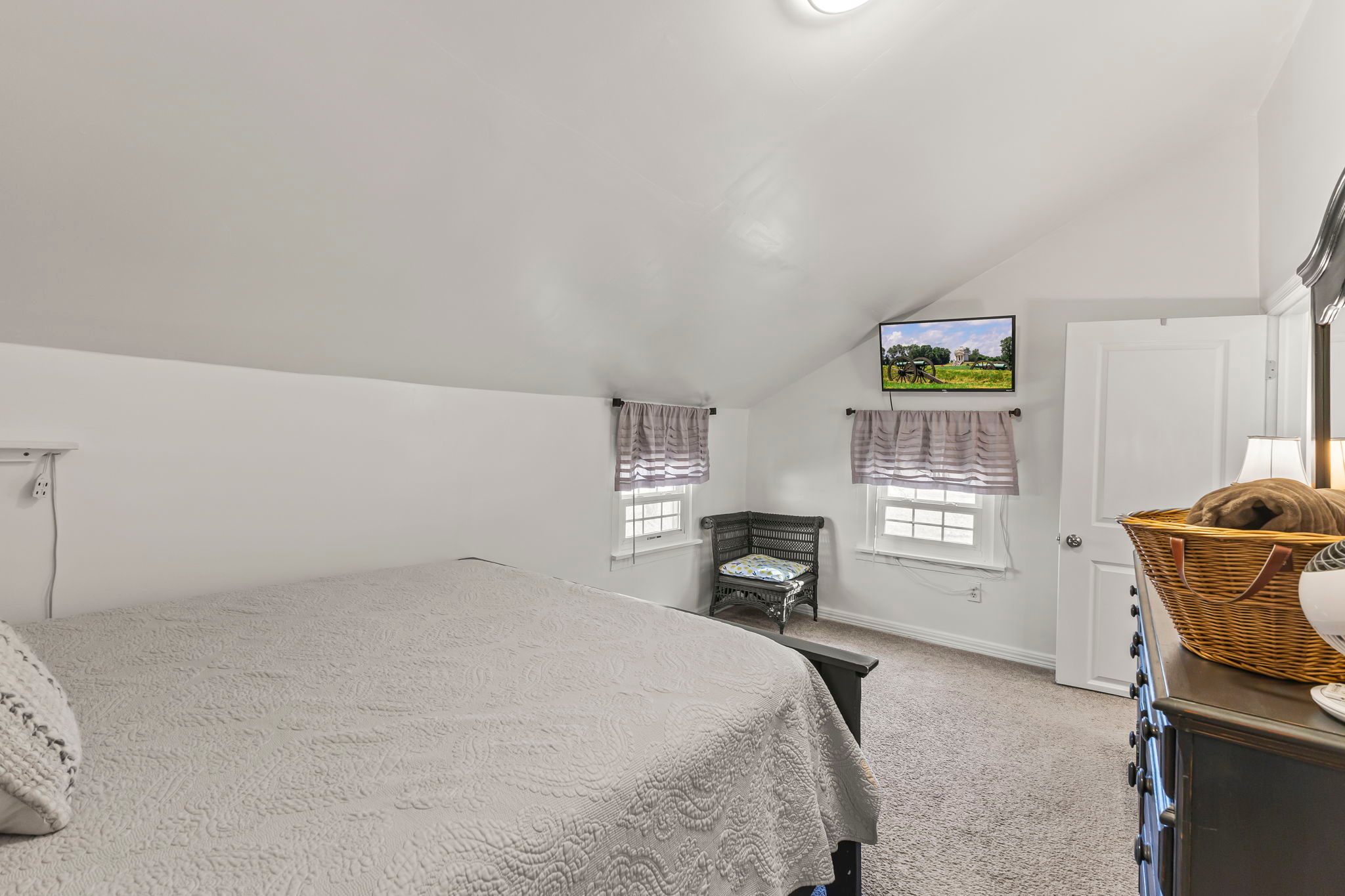 Queen size bed with dresser, closet and tv. 
