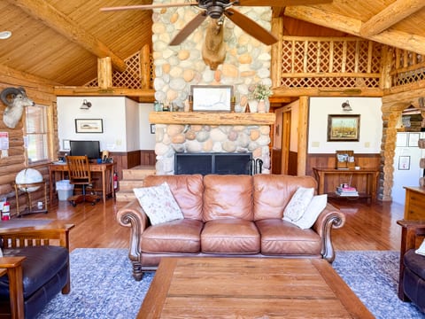 Great room seating is comfortable and ample. This view shows the fireplace and loft areas as well as the work space.