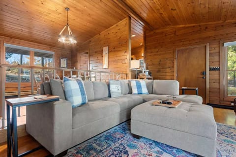 Greeting you in the living room is an inviting stone fireplace, cozy sofa, and two drink tables - perfect for kicking back with friends and family during your stay in Door County.