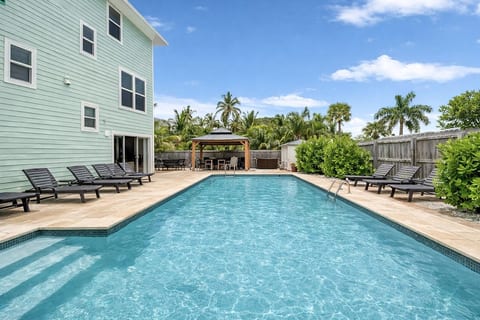 Private heated pool with lounge seating and shaded outdoor dining — perfect for relaxing, gathering, and making family memories