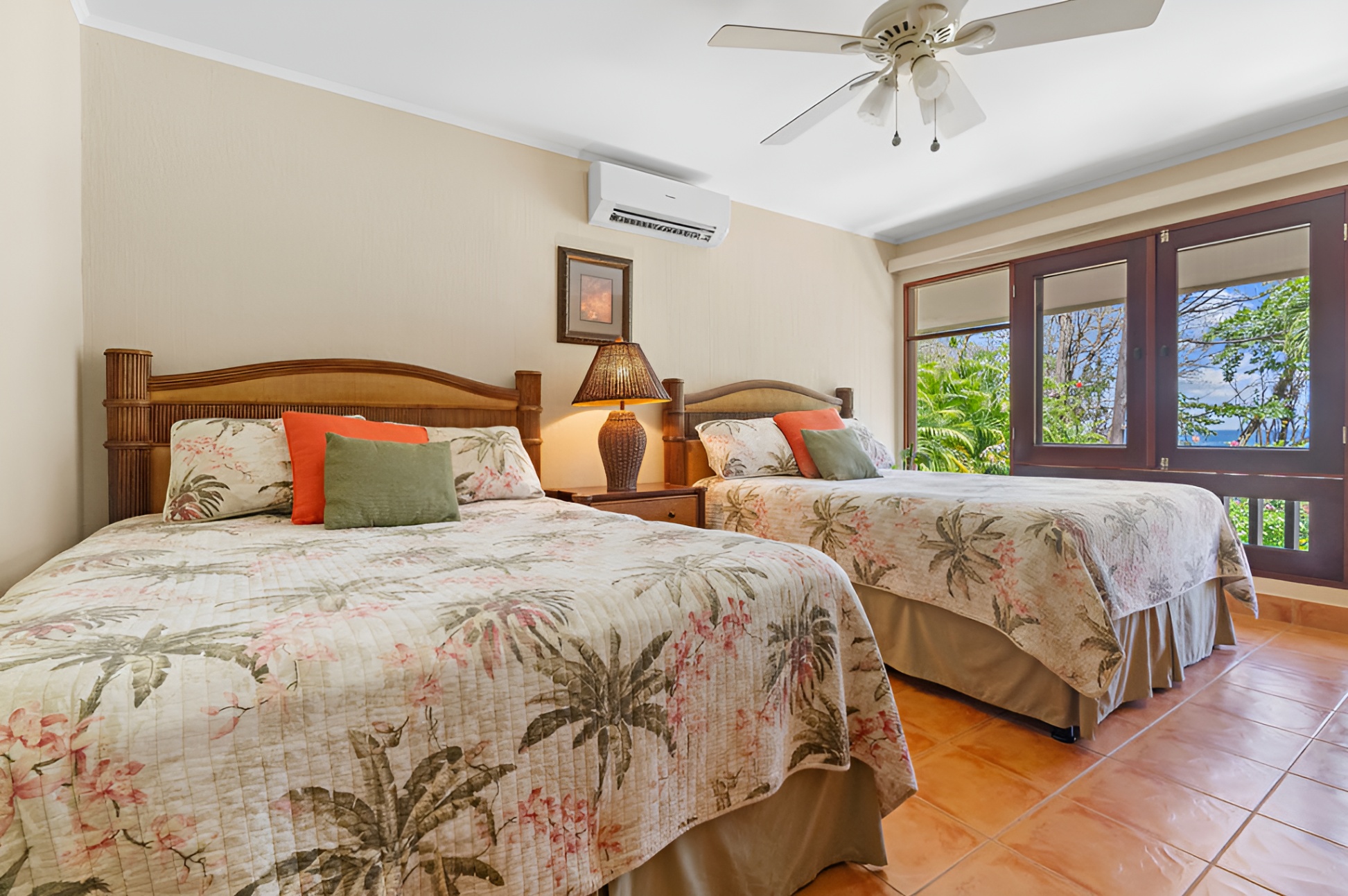 The second oceanfront bedroom is spacious and tropical, has has two queen beds.