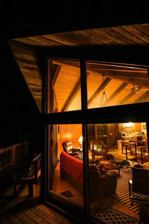 Nighttime view into the house from the chalet's wraparound deck