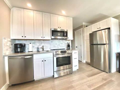 All new fully-stocked designer kitchen with full-size stainless appliances & marble backsplash!