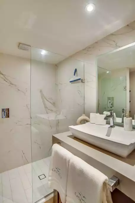 The guest bathroom features a large basin and mirror.