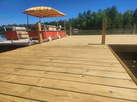 “Take a stroll down your sturdy, 8-foot-wide love-walk — a brand-new dock built for sunset chats, shared snacks, and stealing kisses over the water. And if you want to level up date-day? The pontoon boat can be included.”