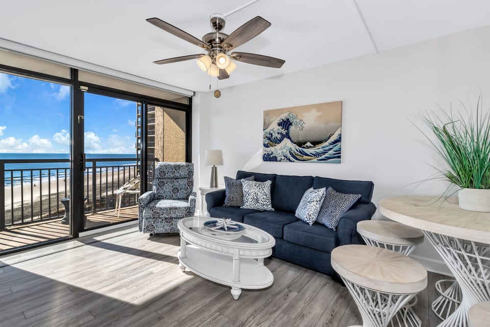 - Relax in a stylish living space with a comfy sofa and coastal-inspired decor - Floor to ceiling windows bring in endless ocean views and natural sunlight - Step onto your private balcony and take in the soothing sound of the waves
