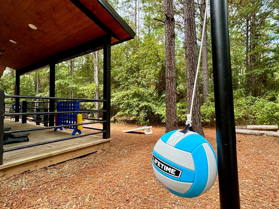 Outdoor fun spot with Connect Four, tetherball, and cornhole in a peaceful nature retreat.